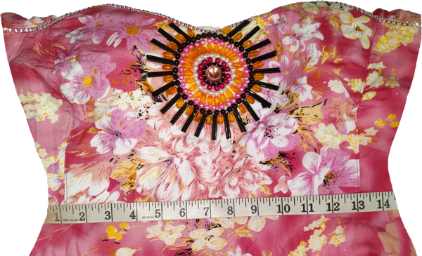 A woman wearing an off-shoulder pink gown Handmade beaded decorative with white patterns and beaded details.