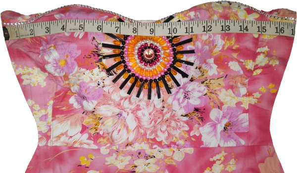 A woman wearing an off-shoulder pink gown Handmade beaded decorative with white patterns and beaded details.