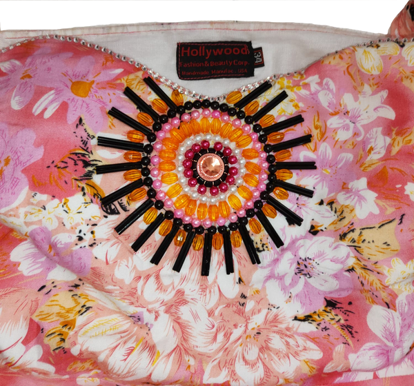 A woman wearing an off-shoulder pink gown Handmade beaded decorative with white patterns and beaded details.