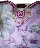 Decorative hand-stitched brooch with beads on a floral-patterned fabric background