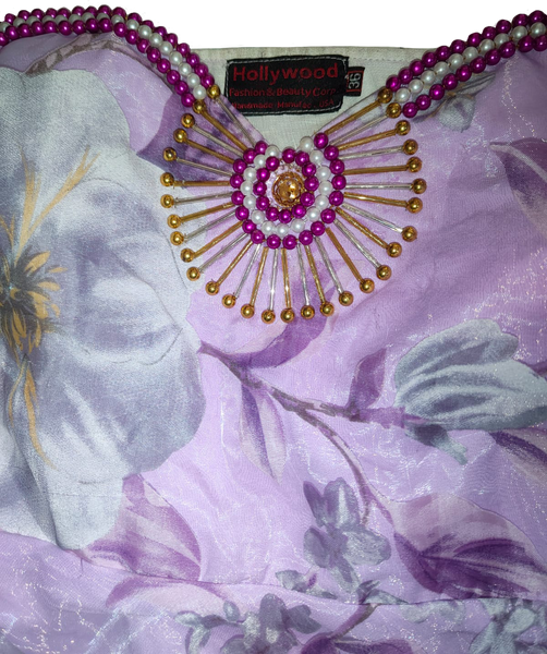 Decorative hand-stitched brooch with beads on a floral-patterned fabric background