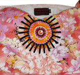 A woman wearing an off-shoulder pink gown Handmade beaded decorative with white patterns and beaded details.
